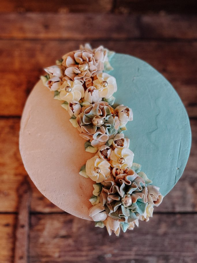 Torte in zwei Farben, verziert mit Blumen und trockenen Blüten.