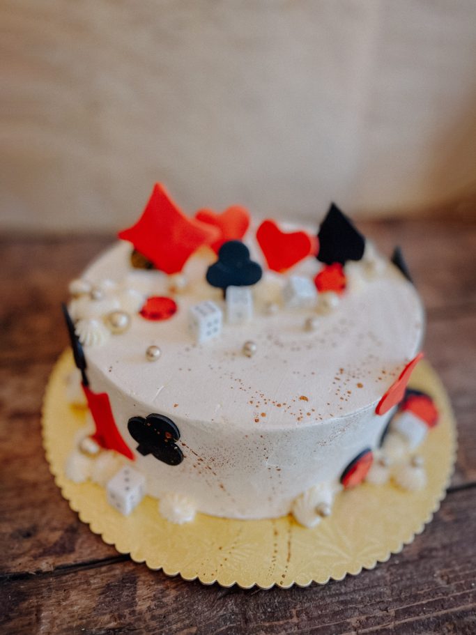 Torte mit weißen und bunten Dekorationen in Herz- und Sternformen.