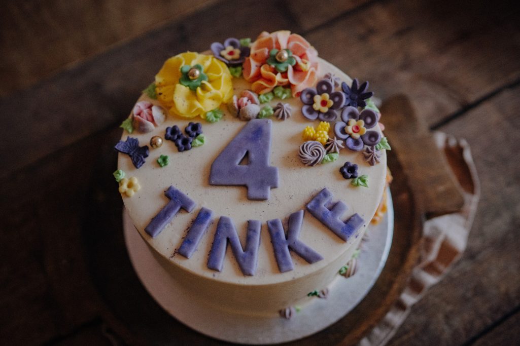 Ein Geburtstagskuchen mit bunten Blumen und der Aufschrift "4 TINKE".