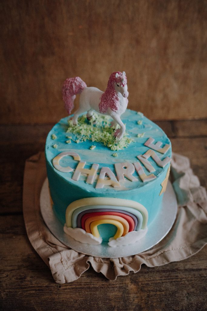 Bunte Torte mit einem Einhorn, Regenbogen und dem Namen "Charlie".