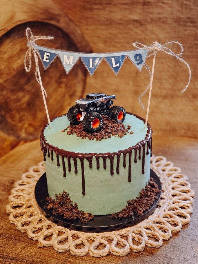 Torte in Mintgrün mit Schokoladenglasur und Traktor-Dekor, mit einem Banner "EMIL".