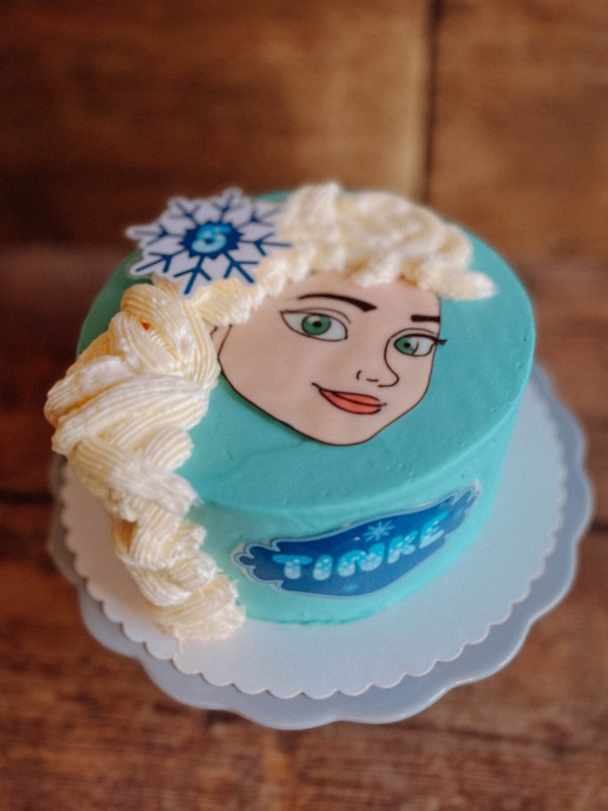 Torte in Türkis mit Elsa-Motiv und Sahneverzierung.